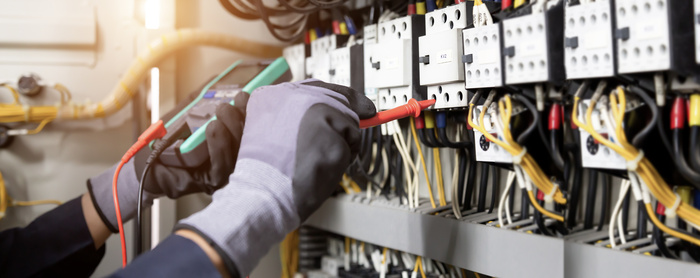 Electrician engineer tests electrical installations and wires on electrical panel